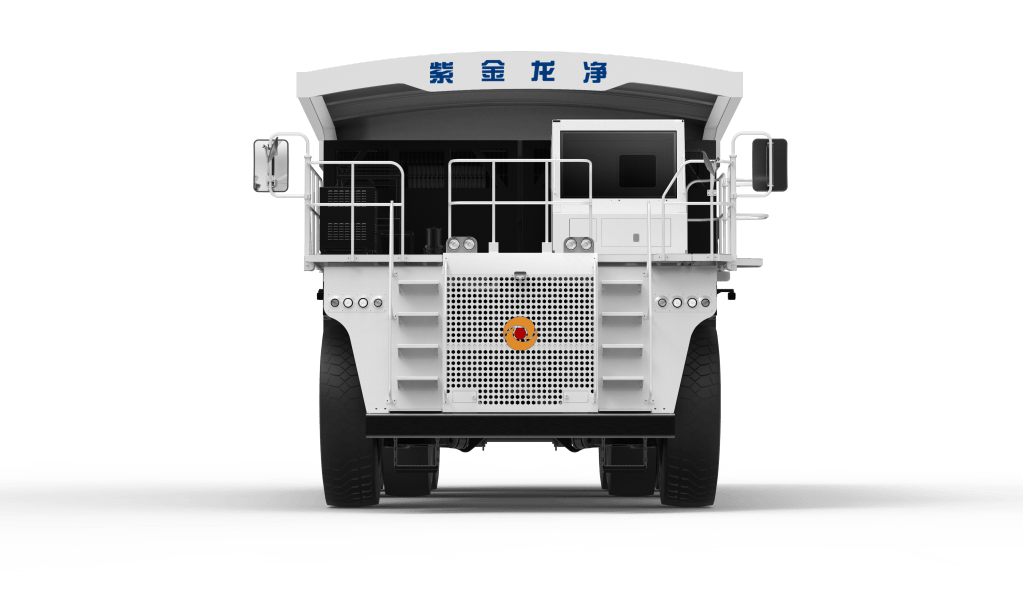 Front view of a large white mining truck with stairs, railings, and a distinctive logo on the front.